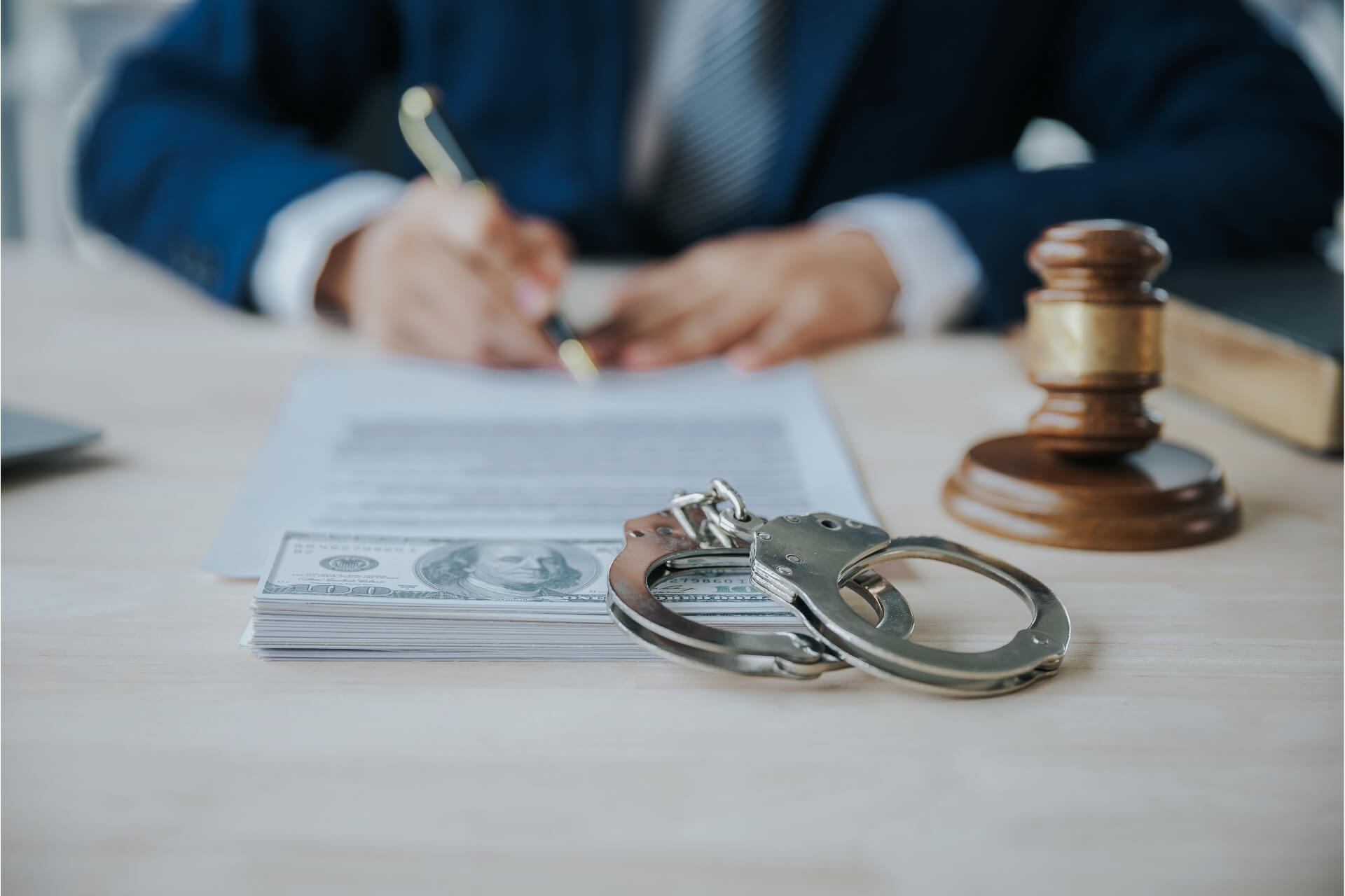 Handcuffs and money on a desk in a portrayal of bail bonds in Titusville.