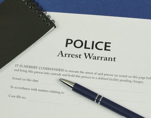 A police warrant is displayed atop a pen and paper in Titusville.