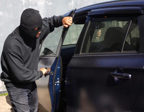 A man in a hoodie opening the door of a car outside a bail bonds office in Titusville.